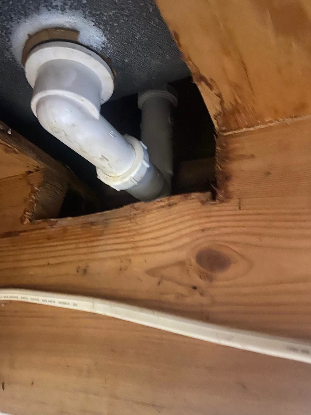 Bathroom drain lines opened up from below to trace a leak