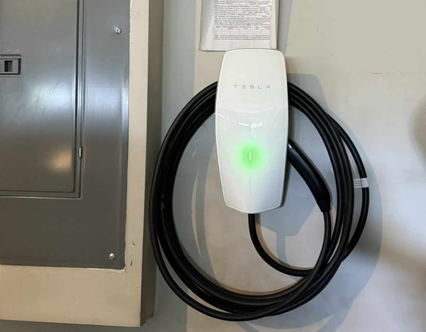 Tesla Wall Connector installed beside the main panel in a Georgia garage, powered and ready