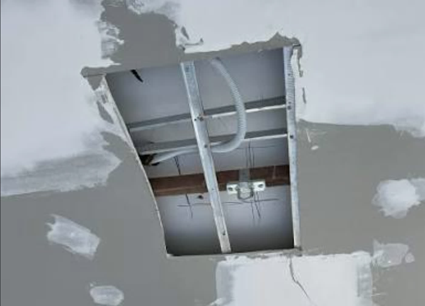 Ceiling opened up to fit a fan-rated brace between the joists before the fan goes back on
